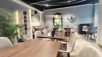 Moderne Einrichtung, Tische stehen bereit, entspannte Restaurantatmosphäre.